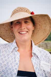 Smiling white woman wearing a straw hat with nametag "Lindie Markovich"