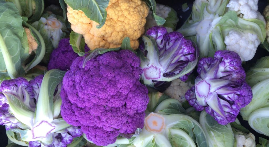 Pile of purple, orange, and white cauliflower florets