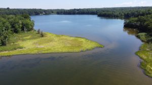 Aerial of river shows narrow spot where land rises between two wider and deeper areas