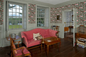 Pink Parlor at Bowman House with floral wallpaper, gray painted trim, and pink upholstered camelback sofa